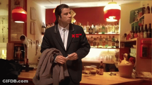 A Man In A Black Suit Has A Red X On His Pocket GIF
