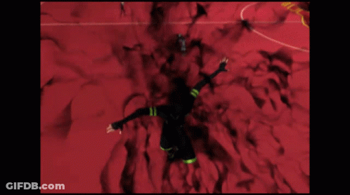 A Man In A Black Suit Is Flying Through A Red Room With A Sign That Says G-Z GIF