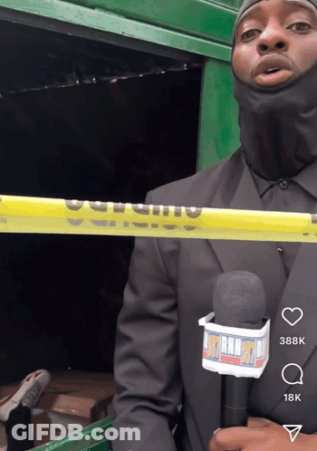 A Man In A Black Suit Is Holding A Microphone With A Lanyard That Says ' Mtn Radio ' On It GIF