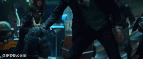 A Man In A Black Suit Is Kneeling Down In Front Of A Group Of Soldiers . GIF