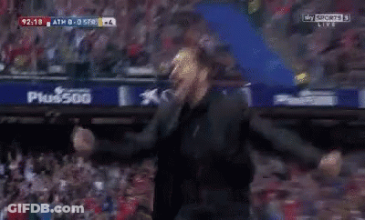 A Man In A Black Suit Is Screaming In A Dark Room While Watching A Sports Game On Sky Sports GIF