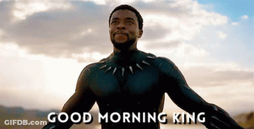A Man In A Black Suit Is Standing In Front Of A Cloudy Sky And Says Good Morning King . GIF
