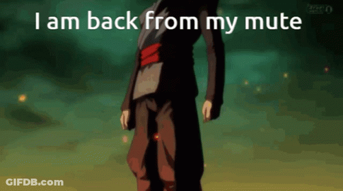 A Man In A Black Suit Is Standing In Front Of A Green Background With The Words I Am Back From My Mute GIF