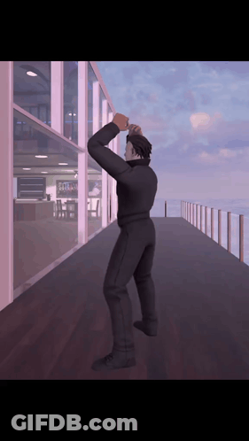 A Man In A Black Suit Is Standing On A Balcony GIF