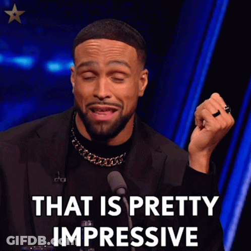 A Man In A Black Suit Is Talking Into A Microphone And Saying That Is Pretty Impressive GIF