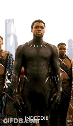 A Man In A Black Suit Stands In Front Of A Group Of Men And The Word Indeed Is Written Below Him GIF