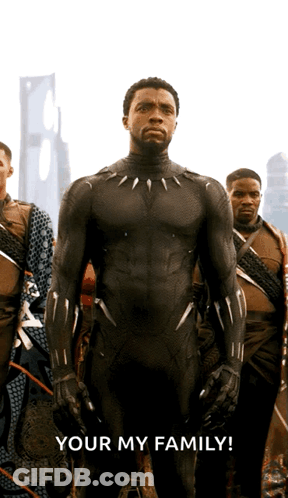 A Man In A Black Suit Stands In Front Of A Group Of Men With The Words Your My Family Below Him GIF