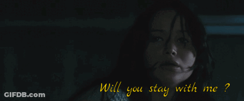 A Man In A Black Suit Stands In Front Of A Window GIF