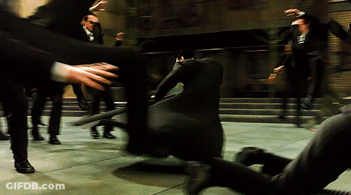 A Man In A Black Suit With The Letter L On The Back Of His Shirt GIF