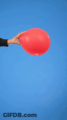 A Man In A Black Sweater Holds A Red Balloon In Front Of A Blue Background GIF