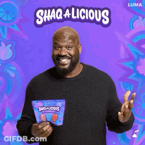 A Man In A Black Sweater Is Holding A Bag Of Gummy Bears And Smiling . GIF