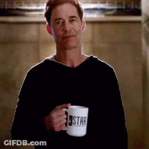 A Man In A Black Sweater Is Holding A Star Mug GIF