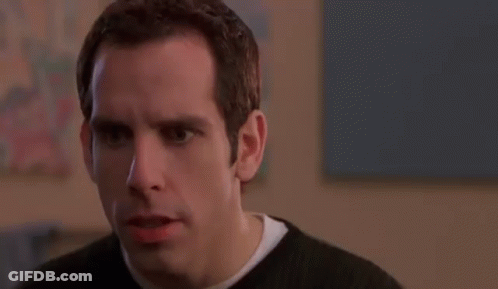 A Man In A Black Sweater Is Making A Funny Face And Looking At The Camera . GIF