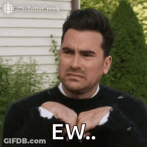 A Man In A Black Sweater Is Making A Funny Face While Holding His Hands Together And Saying Ew . GIF