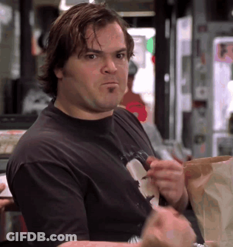 A Man In A Black T-Shirt Is Eating A Bag Of Chips GIF
