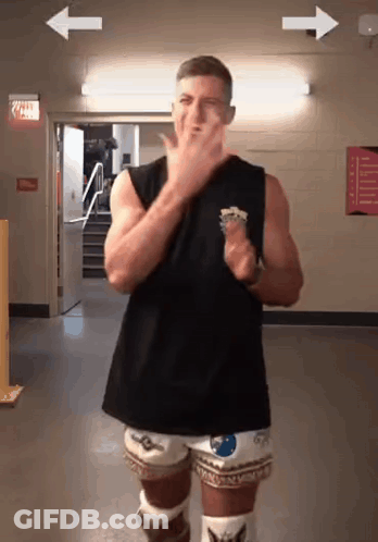 A Man In A Black Tank Top And White Shorts Is Dancing GIF