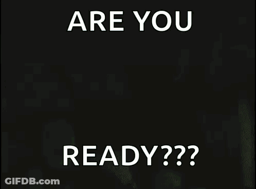 A Man In A Black Tank Top Is Holding A Sign That Says Are You Ready GIF