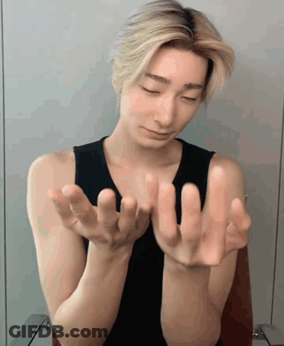 A Man In A Black Tank Top Is Holding His Hands Out GIF