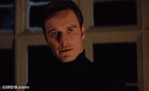 A Man In A Black Turtleneck Stands In Front Of A Window With Perfection Written On The Bottom Right GIF