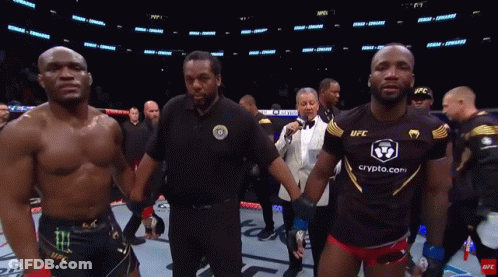 A Man In A Black Ufc Shirt Stands Next To Another Man GIF