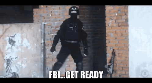 A Man In A Black Uniform Is Standing In Front Of A Brick Wall And Says Fbi Get Ready GIF
