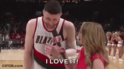 A Man In A Blazers Jersey Is Being Interviewed By A Woman Holding A Microphone . GIF