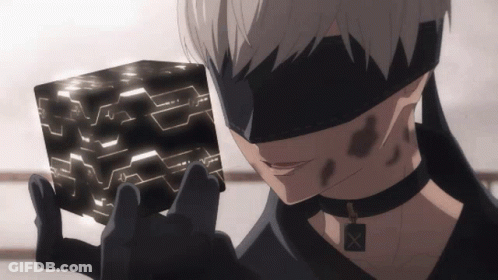 A Man In A Blindfold Is Holding A Black Cube In His Hands GIF