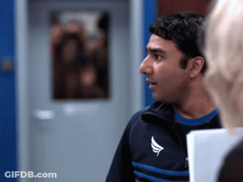 A Man In A Blue And Black Jacket With A White Wing On The Front GIF