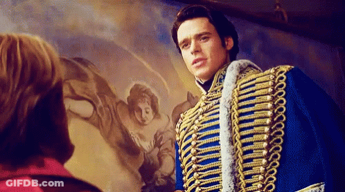 A Man In A Blue And Gold Military Uniform Is Standing In Front Of A Painting Of A Woman . GIF