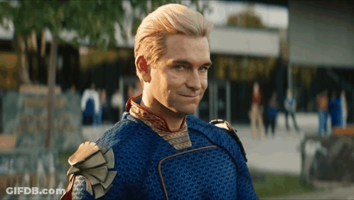 A Man In A Blue And Gold Superhero Costume Is Smiling GIF