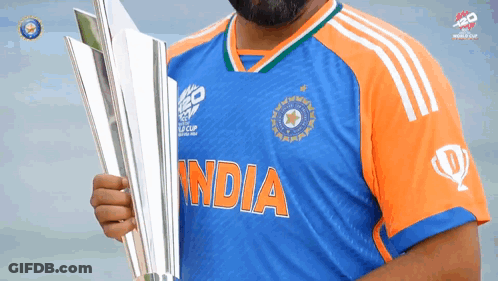 A Man In A Blue And Orange India Jersey Holds A Silver Trophy GIF