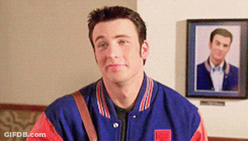 A Man In A Blue And Red Jacket Is Standing In Front Of A Framed Picture GIF