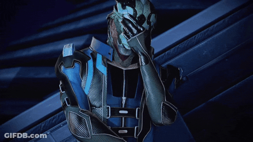 A Man In A Blue And Silver Suit Holds His Hand Over His Face GIF
