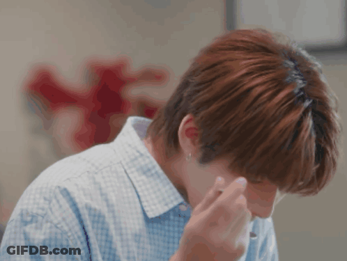 A Man In A Blue And White Checkered Shirt Wipes His Nose GIF