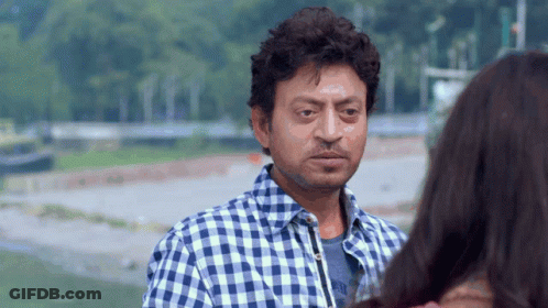 A Man In A Blue And White Plaid Shirt Is Looking At A Woman GIF