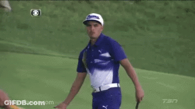 A Man In A Blue And White Shirt Is Standing On A Golf Course GIF