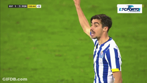 A Man In A Blue And White Striped Shirt Holds Up His Fist GIF