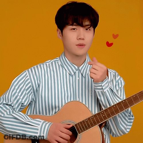 A Man In A Blue And White Striped Shirt Is Holding A Guitar GIF