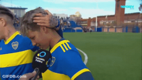 A Man In A Blue And Yellow Jersey Is Being Interviewed By A Microphone That Says Television Publico GIF