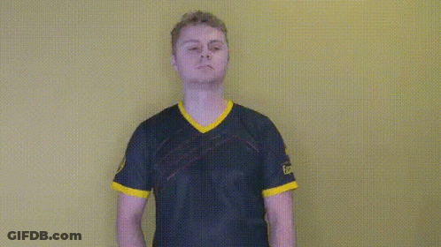 A Man In A Blue And Yellow Shirt Is Standing In Front Of A Yellow Background . GIF