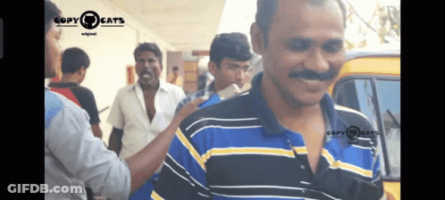 A Man In A Blue And Yellow Striped Shirt Is Being Touched By Another Man In A Copy Cats Video GIF