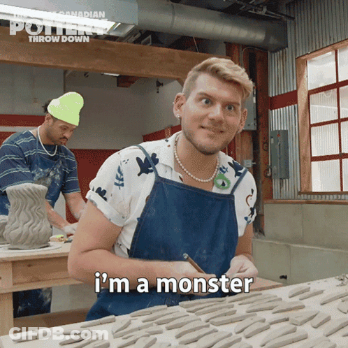 A Man In A Blue Apron Says I 'M A Monster In Front Of A Table Full Of Clay GIF