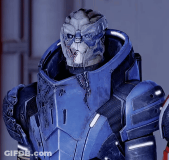 A Man In A Blue Armor With A White Face Is Looking At The Camera GIF