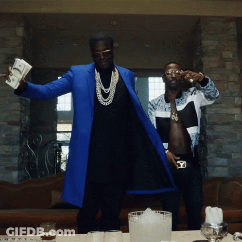 A Man In A Blue Coat Holds A Stack Of Money In His Hand GIF