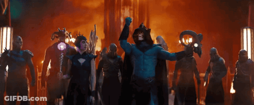 A Man In A Blue Costume Is Holding A Purple Object GIF