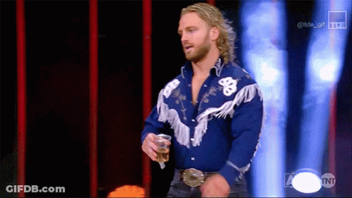 A Man In A Blue Cowboy Shirt Is Holding A Drink GIF