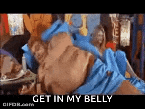 A Man In A Blue Dress Is Laying On A Bed With The Words `` Get In My Belly '' Written On The Bottom GIF