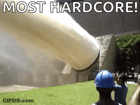A Man In A Blue Hard Hat Is Standing In Front Of A Large Pipe That Is Being Thrown Into The Air . GIF