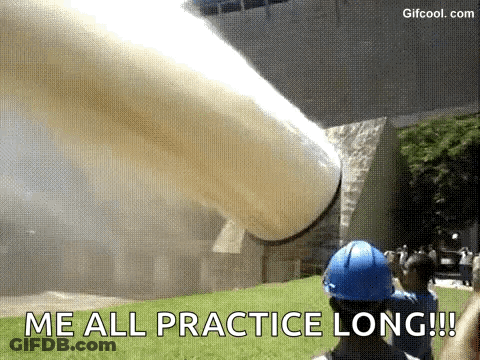 A Man In A Blue Hard Hat Is Standing In Front Of A Large Pipe That Is Blowing Smoke . GIF