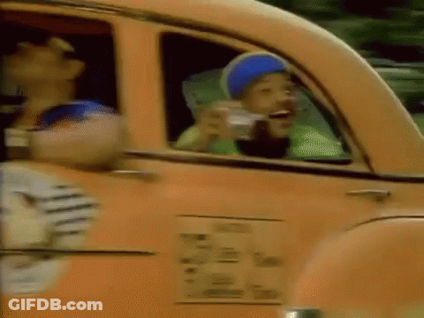 A Man In A Blue Hat Is Drinking From A Cup While Sitting In A Car . GIF
